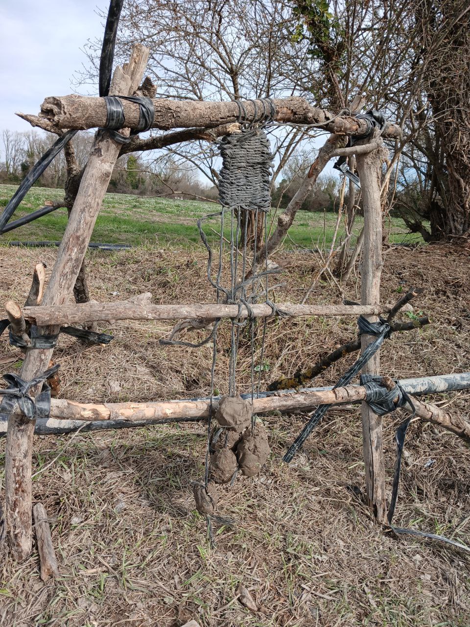 Un métier à tisser de fortune, en bois lié à la main